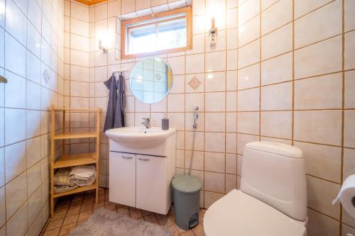 a bathroom with a toilet and a sink and a mirror at Villa River- Luxury Lapland Cabin in Kittilä