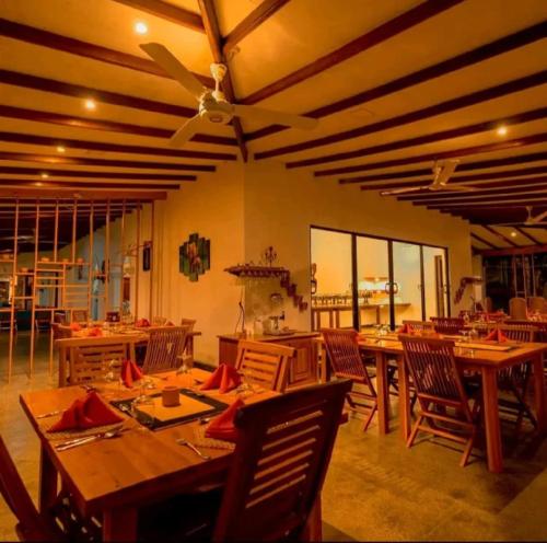 a dining room with wooden tables and chairs at Hotel Longteng in Sigiriya
