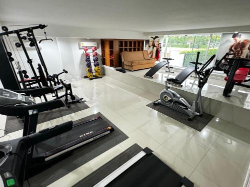 Un gimnasio con varias cintas de correr y máquinas en una sala. en Prestige, en Bangna