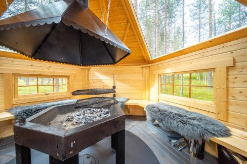 a log cabin with a stove in a room at Villa River- Luxury Lapland Cabin in Kittilä