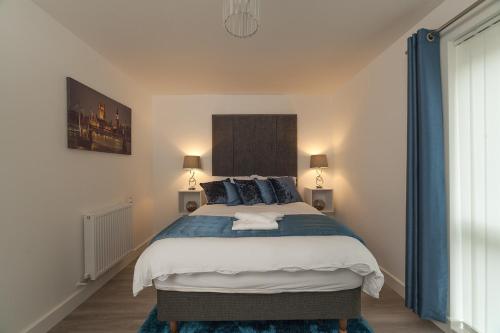 a bedroom with a large bed with blue pillows at Luxury In2 London Apartment in London