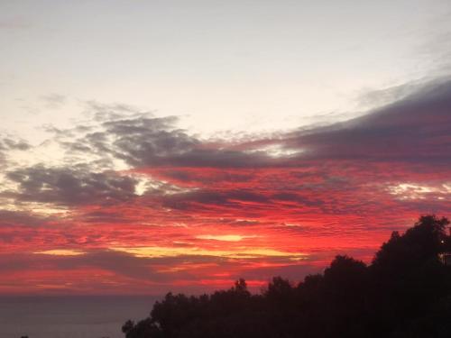 a sunset with red clouds in the sky at Kabak Armes Otel in Fethiye