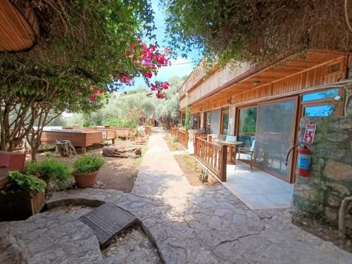 a patio of a house with a table and benches at Kabak Armes Otel in Fethiye