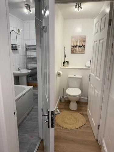 a bathroom with a toilet and a tub and a sink at 3 Bed Near Coventry Arena, Contractor & Family Accommodation in Coventry