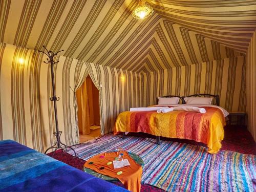 1 dormitorio con 2 camas en una tienda de campaña en Auberge Sahara Garden, en Lac Yasmins