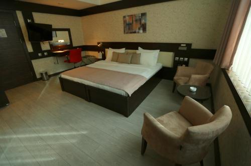 a hotel room with a bed and a chair at Wes Hotel in Kocaeli