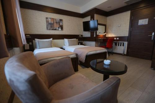 a hotel room with two beds and a couch at Wes Hotel in Kocaeli