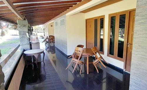a porch with two chairs and a table at Montana Hotel Kuningan in Panawuan