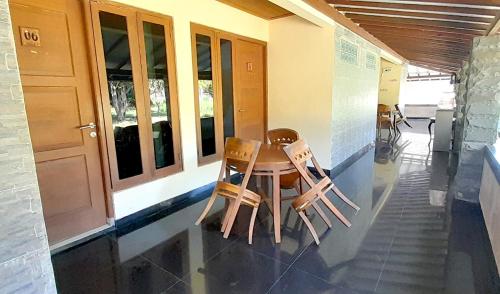 two chairs sitting around a table in front of a building at Montana Hotel Kuningan in Panawuan