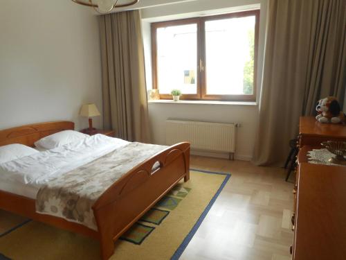 a bedroom with a large bed and a window at Gdynia Orlowo Honey Apartment in Gdynia
