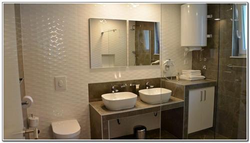a bathroom with two sinks and a mirror at Apartments Mango in Baška