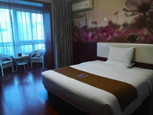 a hotel room with a large bed and a table at PAI Hotels·Shijiazhuang Development Zone Tianshan Science and Technology Park in Shijiazhuang