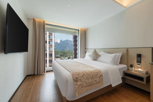 a bedroom with a white bed and a large window at Xiaduo B&B in Wangjiazhai