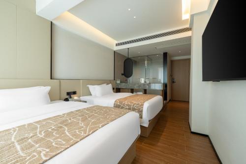 a hotel room with two beds and a television at Xiaduo B&B in Wangjiazhai
