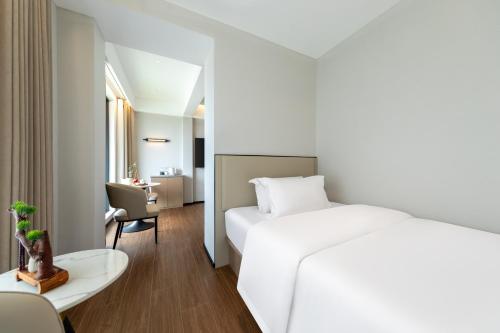 a hotel room with a white bed and a desk at Xiaduo B&B in Wangjiazhai