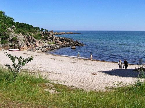 a group of people riding horses on the beach at 4 person holiday home in Gudhjem-By Traum in Gudhjem