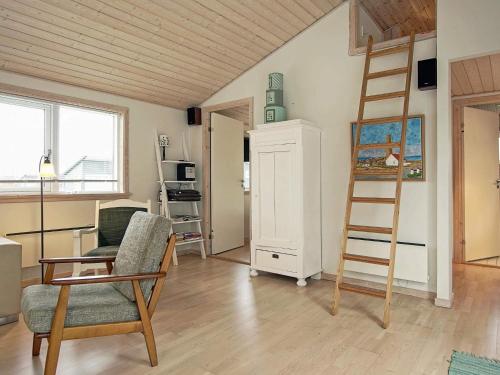 a living room with a ladder and a chair at 4 person holiday home in Gudhjem-By Traum in Gudhjem
