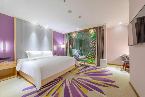 ein Schlafzimmer mit einem großen Bett und einem großen Fenster in der Unterkunft Lavande Hotel Guangzhou Zengchen Xintang Light Railway Station in Zhongtang