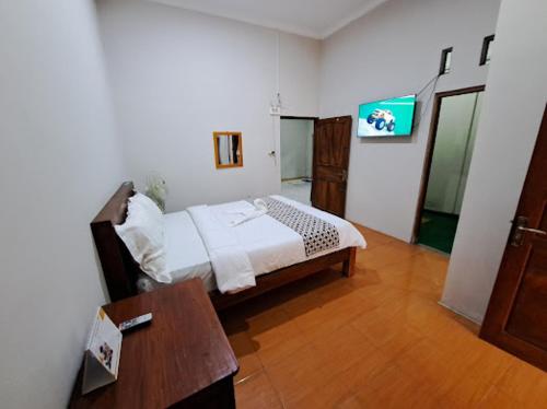 a bedroom with a bed and a table in a room at Romadhoni Homestay in Magelang