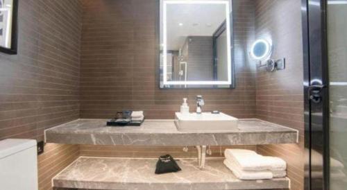 a bathroom with a sink and a mirror at Xana Hotelle Zhuhai Gongbei Port in Zhuhai
