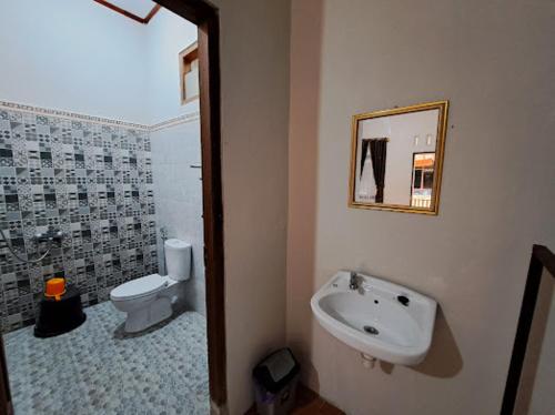 a bathroom with a sink and a toilet at Romadhoni Homestay in Magelang