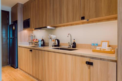 a kitchen with wooden cabinets and a sink at The Residences at Novotel Tower in Manila