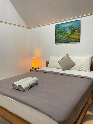 a bed with two towels on top of it at The Iris Vulcano's in Kubupenlokan