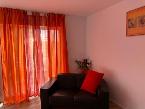 a living room with a couch in front of a window at Guest House BiBi in Ilsfeld