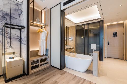 a bathroom with a large tub and a sink at Shanghai Yunhe Yebo Hotel, Wuning Road Global Harbor Branch in Shanghai