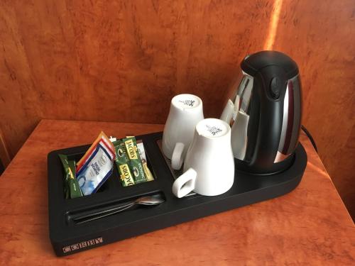 a black tray with a coffee pot and cups on a table at Hotel West an der Bockenheimer Warte in Frankfurt/Main