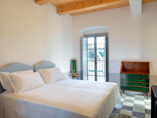 a bedroom with a white bed and a piano at I Casali del Pino in La Giustiniana
