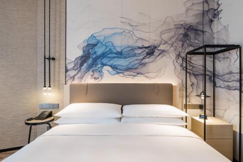 a bedroom with a bed and a painting on the wall at Shanghai Yunhe Yebo Hotel, Wuning Road Global Harbor Branch in Shanghai