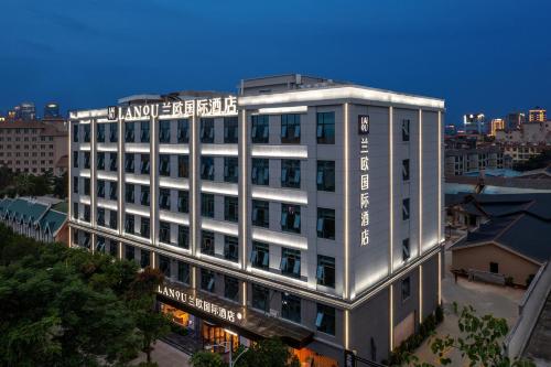 a white building with a sign on top of it at Lan Ou International Hotel in Ruili
