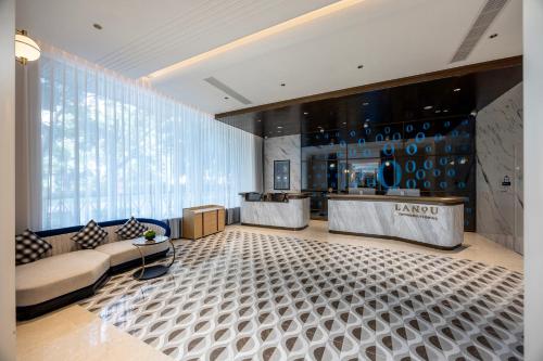 a lobby with a waiting area and a large window at Lan Ou International Hotel in Ruili