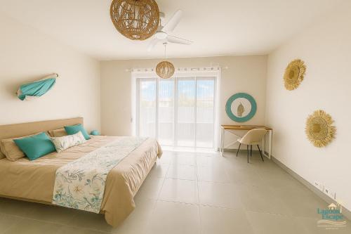 une chambre avec un lit et un ventilateur de plafond dans l'établissement Residence ORYAM, à Trou aux Biches