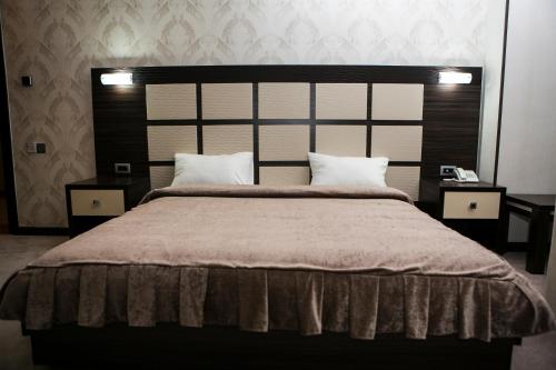 a bedroom with a large bed with two pillows at Azalea Hotel Baku in Baku