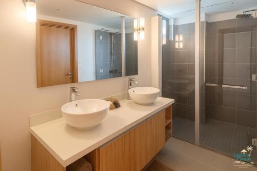une salle de bain avec deux lavabos et une douche dans l'établissement Residence ORYAM, à Trou aux Biches