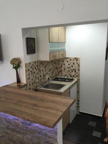 a kitchen with a sink and a stove at Apartments MaXhit in Tivat
