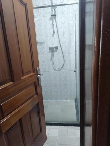 a bathroom with a shower with a glass door at Mission Inn in Kigali