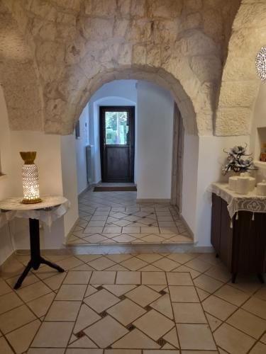 a hallway with a stone floor and a door at Avventure tra i trulli in Martina Franca