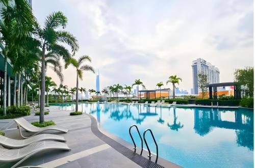 クアラルンプールにあるTrion Hotel by HAVENZA near TRX, Time Square and Bukit Bintangのヤシの木と建物のあるスイミングプール