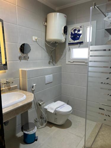 a bathroom with a toilet and a sink at Jewel Dokki Hotel in Cairo