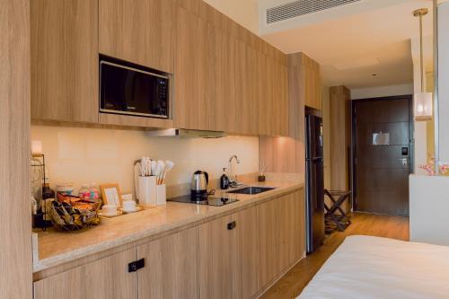 a kitchen with wooden cabinets and a counter top at The Residences at Novotel Tower in Manila