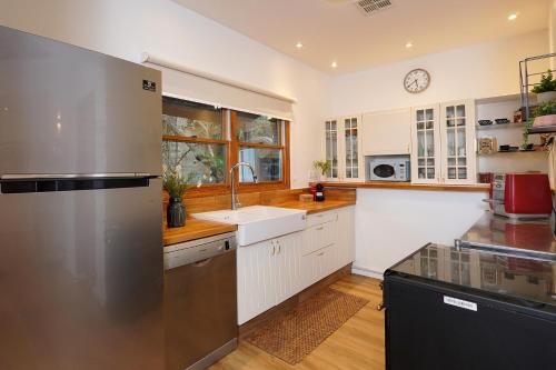 a kitchen with white cabinets and a stainless steel refrigerator at הבית בראש פינה - The House in Rosh Pinna