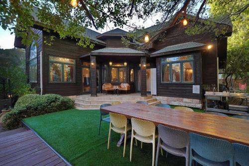 a wooden table and chairs in front of a house at הבית בראש פינה - The House in Rosh Pinna