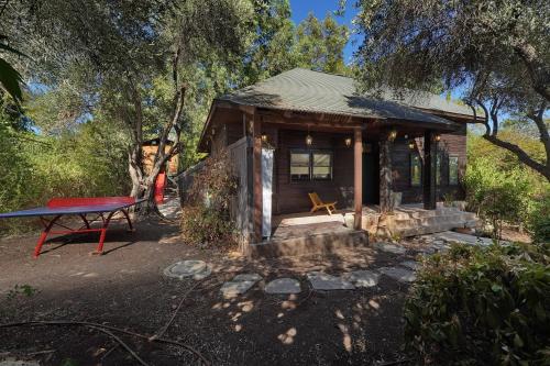a small cabin with a picnic table in front of it at הבית בראש פינה - The House in Rosh Pinna