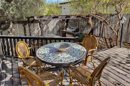 a table and chairs on a wooden deck at הבית בראש פינה - The House in Rosh Pinna