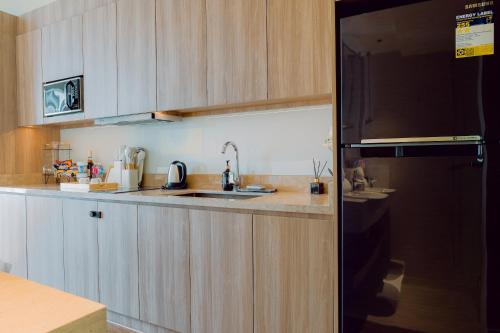 a kitchen with wooden cabinets and a sink at The Residences at Novotel Tower in Manila