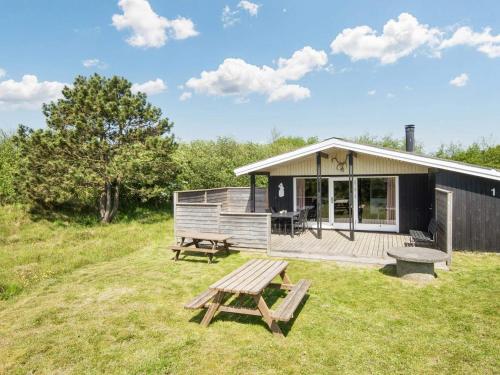a cabin with a picnic table and a bench at Cozy Sauna House with BBQ - By Traum Ferienwohnungen in Fanø
