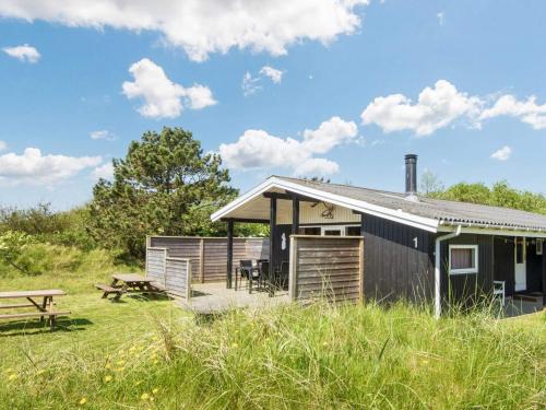 a cabin in a field with a picnic table at Cozy Sauna House with BBQ - By Traum Ferienwohnungen in Fanø